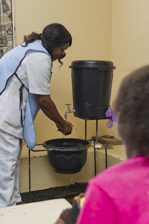 A nurse in Zambia washes her hands