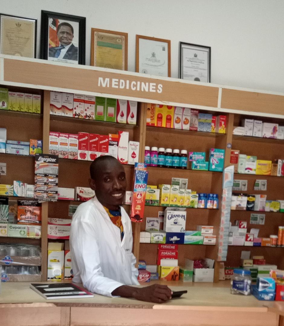 Man smiling behind a pharmacy counter
