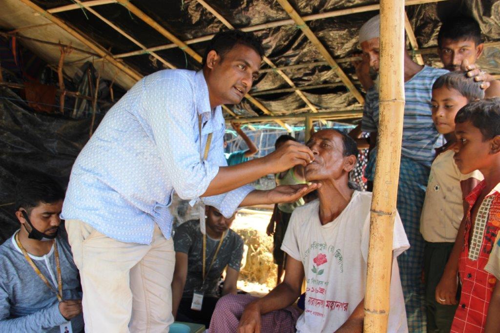 A member of icddr,b's team delivers an oral cholera vaccine to an adult male