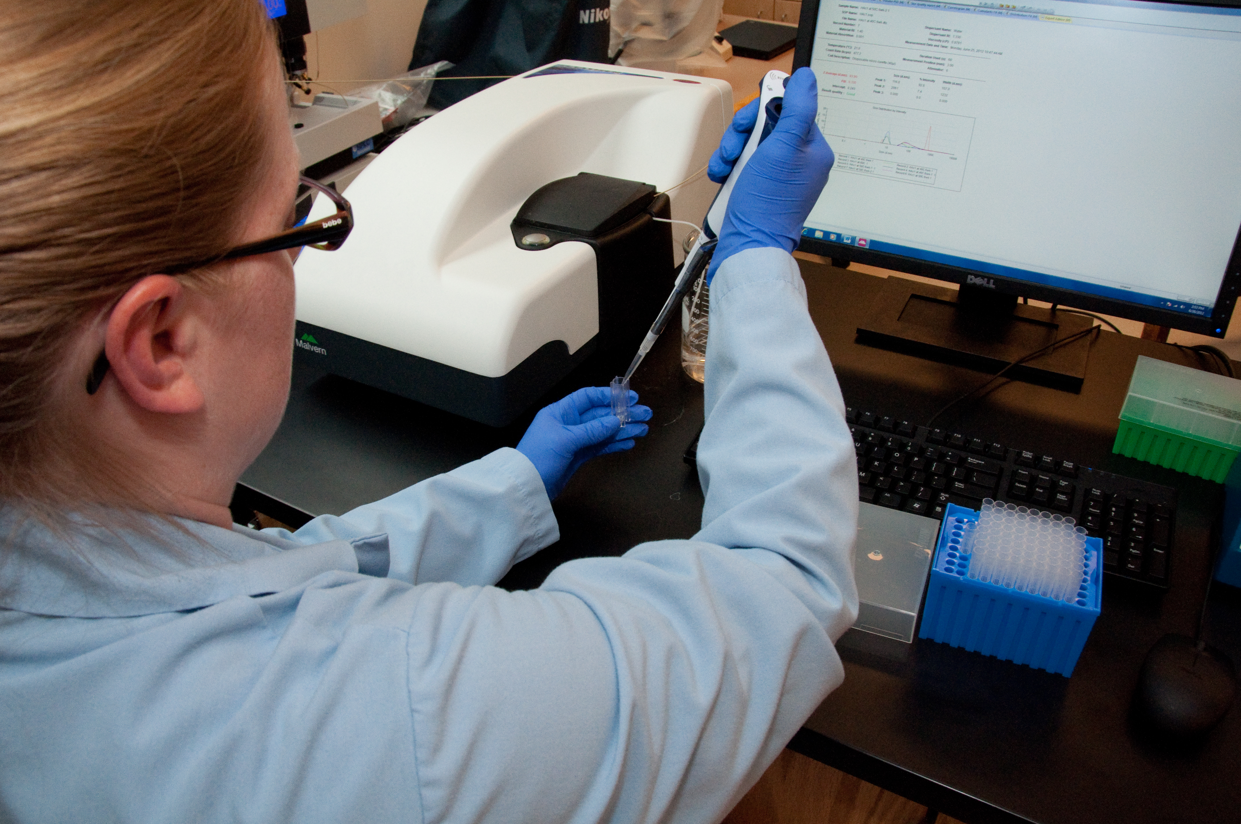 Scientist fills assay plate with sample