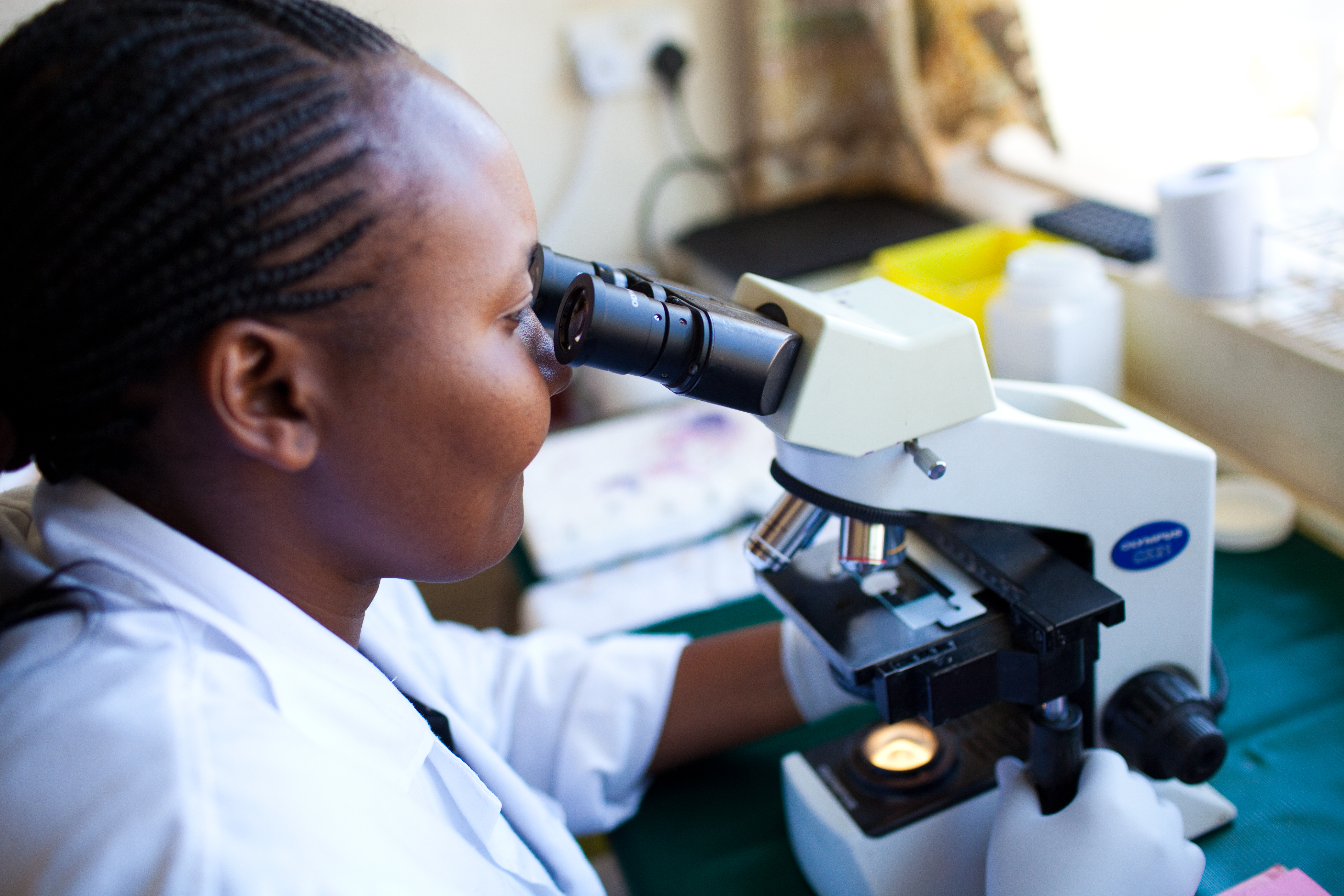 Laboratory technician in Kenya looks in a microscope