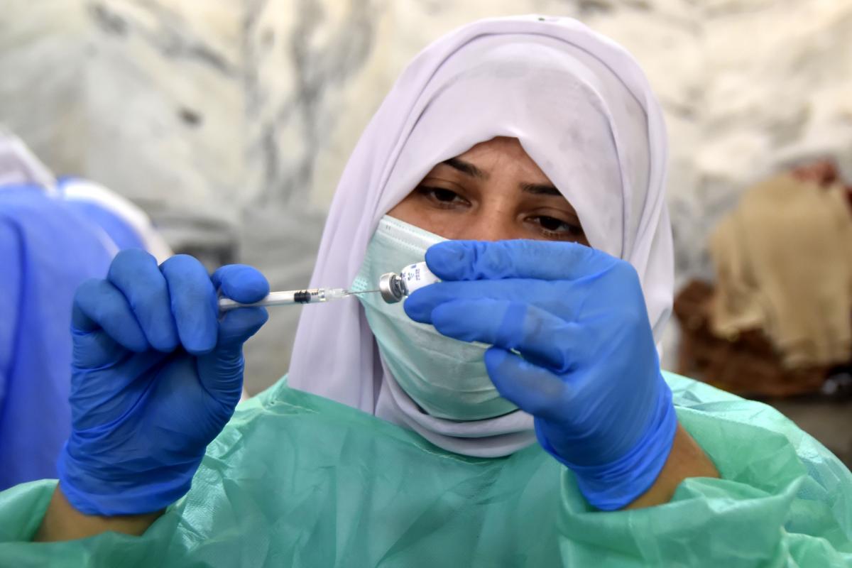 A medical worker prepares a dose of a COVID-19 vaccine in Peshawar, Pakistan, March 2021. Saeed Ahmad Xinhua / eyevine / R​edux