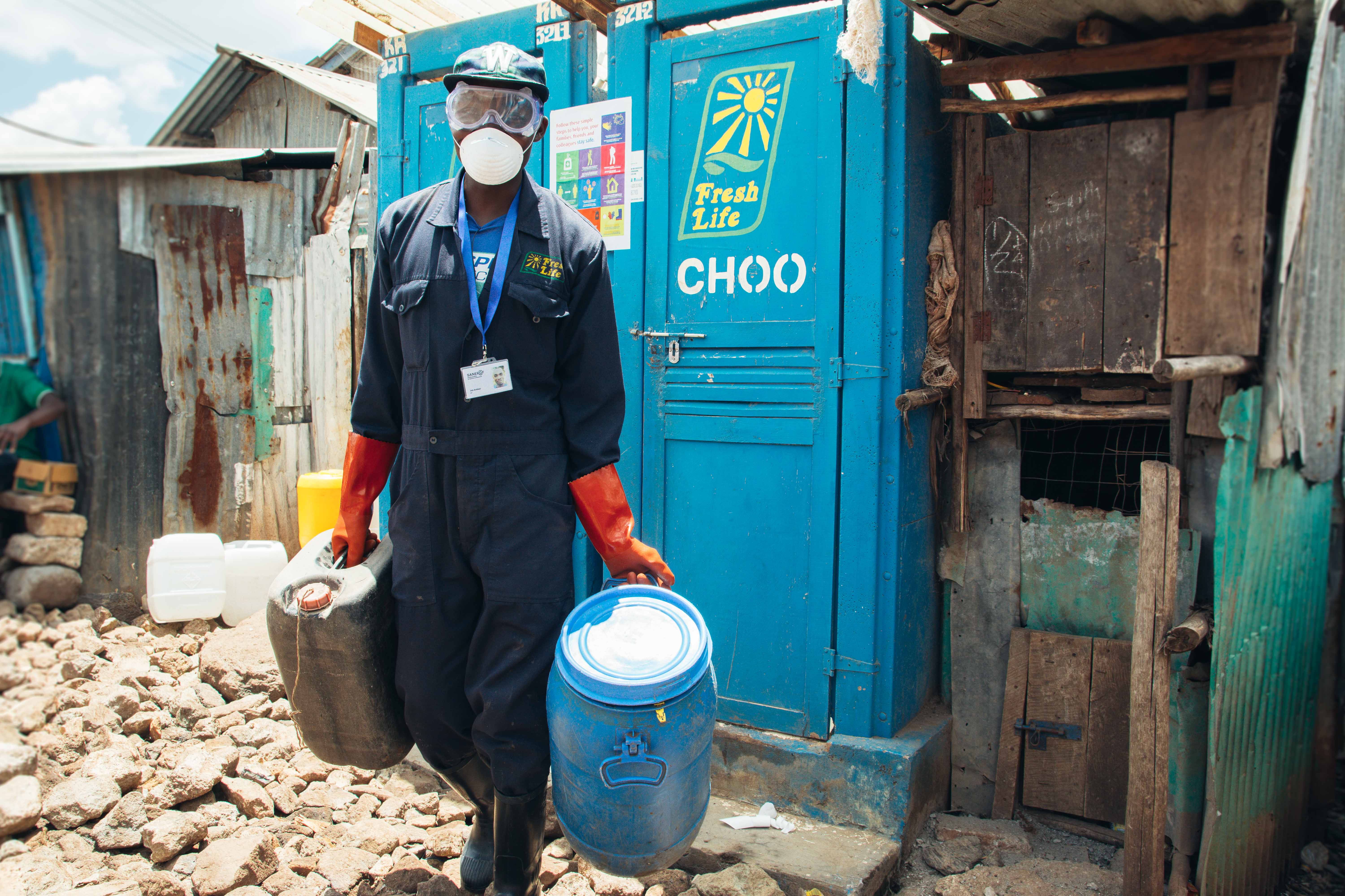 Sanergy employee collecting waste from container toilets