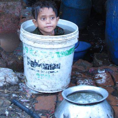 A boy is taking a bath in the Mohammadpur slum in Dhaka, Bangladesh.
