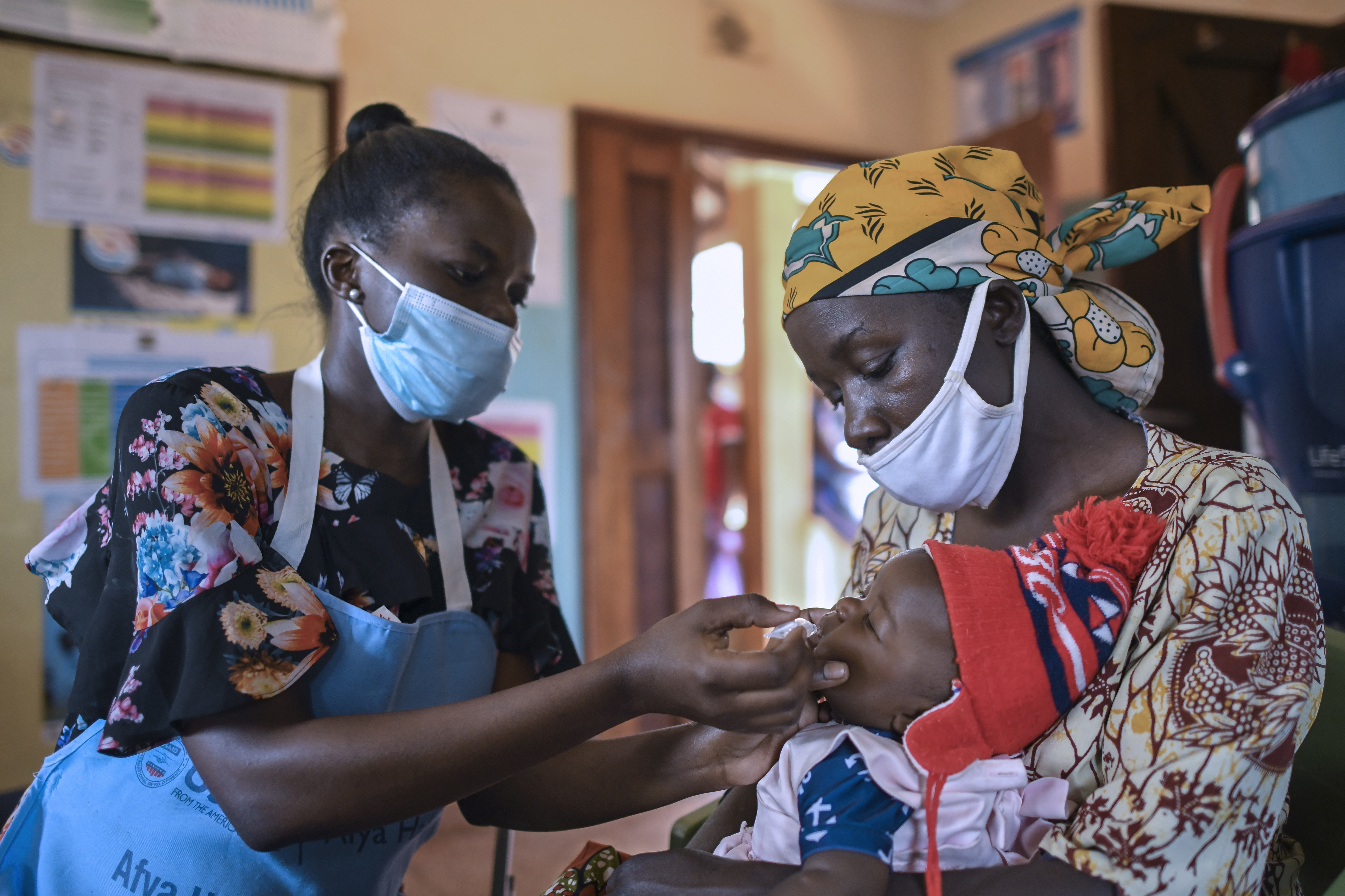 Annet Onyamasi (left) administers an oral rotavirus vaccine to an infant in Khwisero, Kenya. PATH/Anthony Karumba