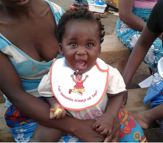 Baby in Malawi wears a bib while eating food