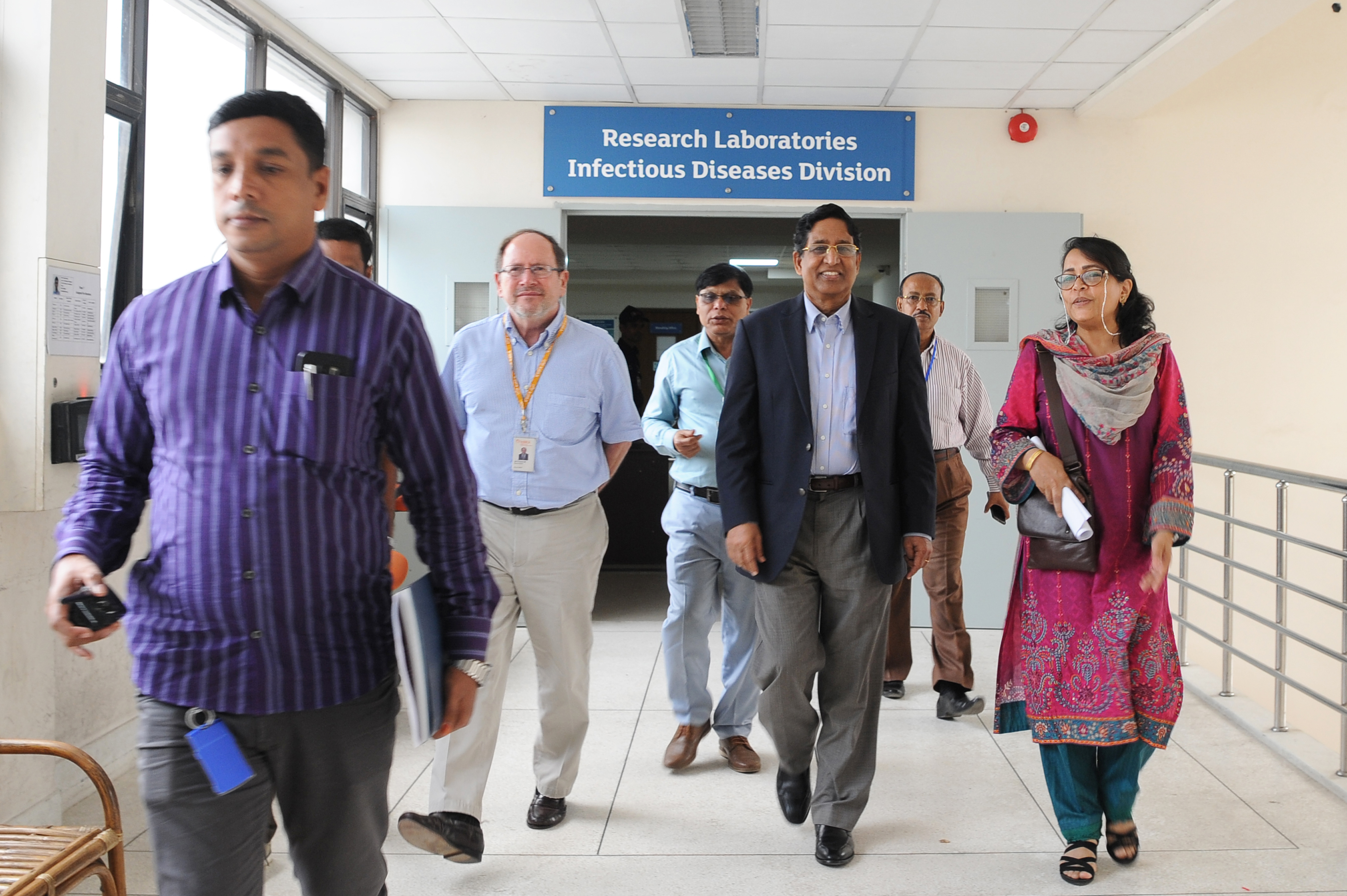 Rubhana walking with a group of male scientists and Bangladesh Agriculture Minister