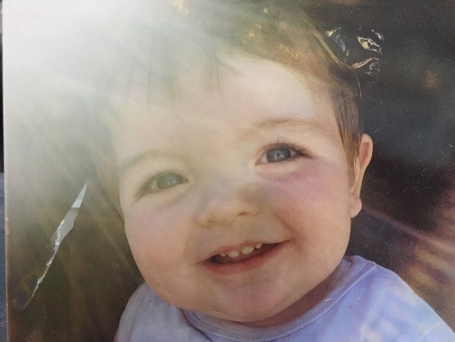 One-year-old boy smiling in sunlight