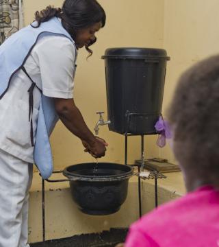 A nurse in Zambia washes her hands
