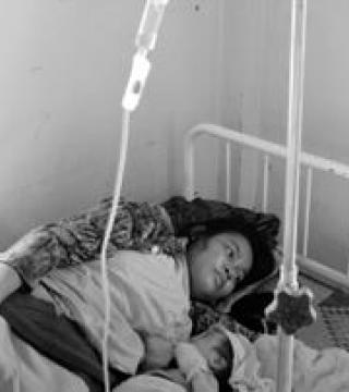 Black and white photo of a mom and baby in a hospital bed