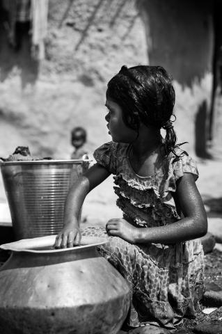 Black and white photo of a girl with a water can