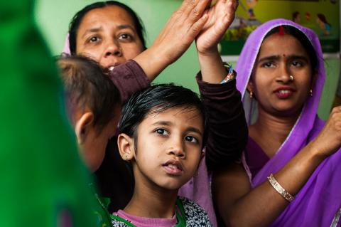 Child in Delhi, India, looking up at community handwashing education