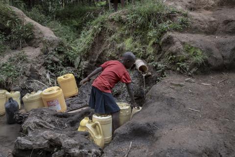 Boy in Kenya gathers water from a well